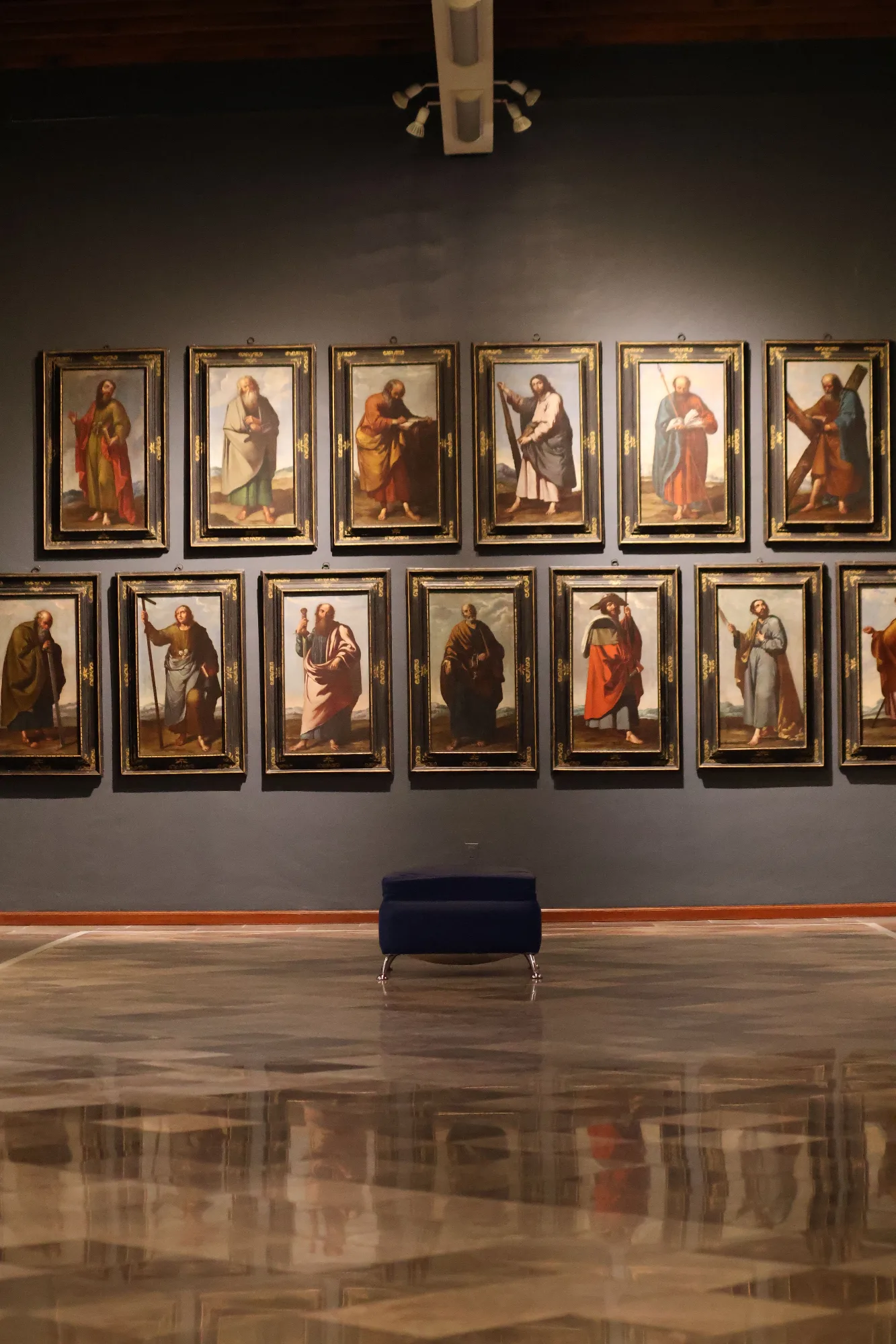 Interior de museo o galería, figura humana de espaldas observando una obra, luz suave.